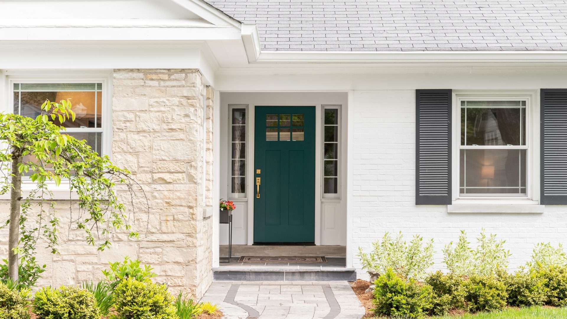 White home with dark green door and white windows in Sag Harbor, NY