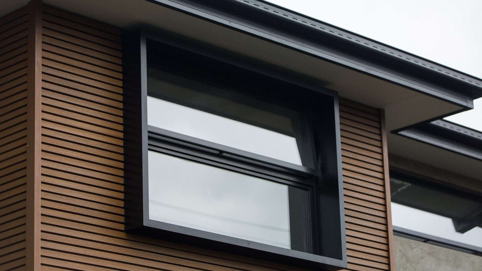 Close exterior view of a rectangular aluminum window on a modern house
