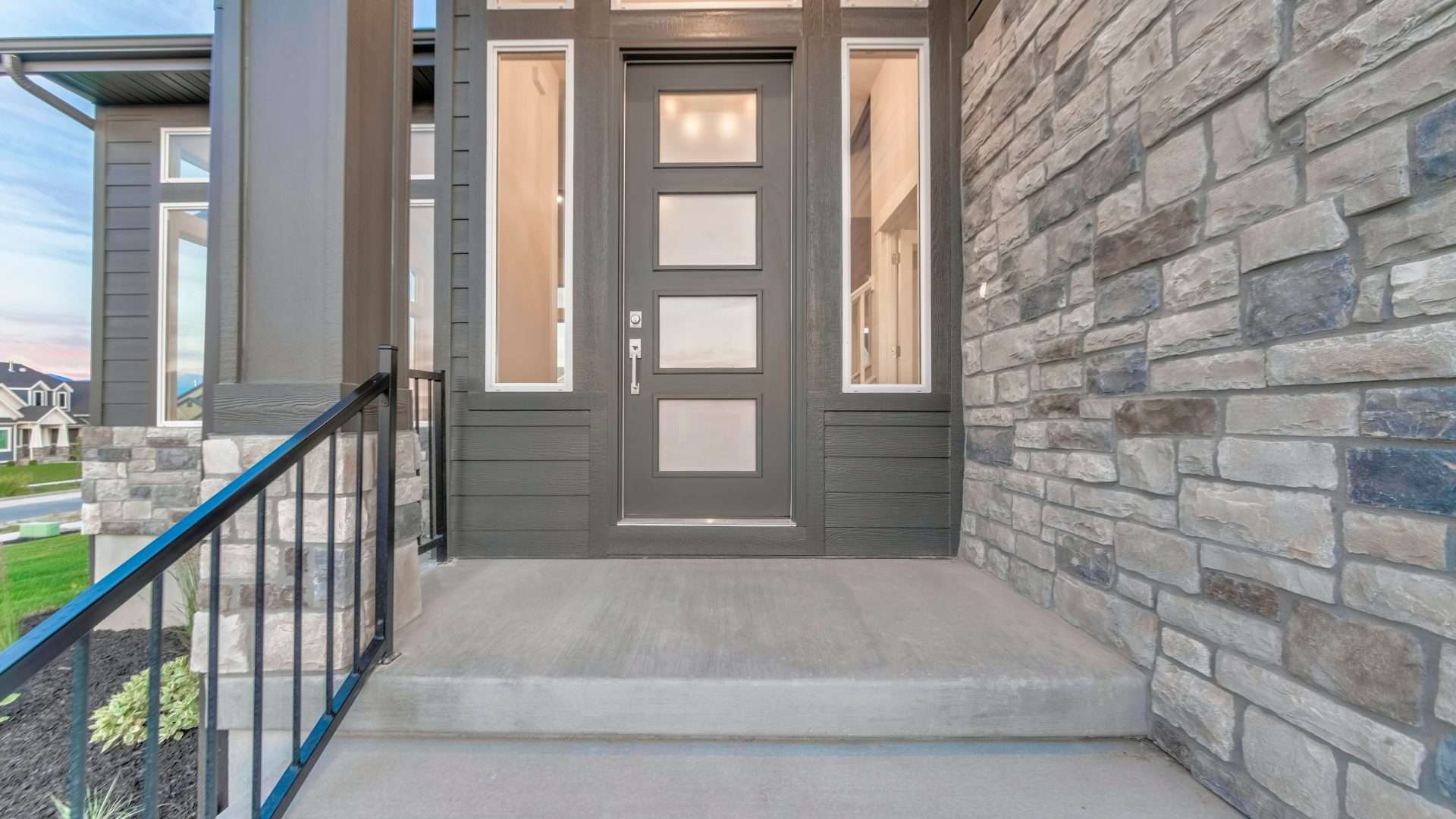 Close view of a custom gray front door on a suburban home