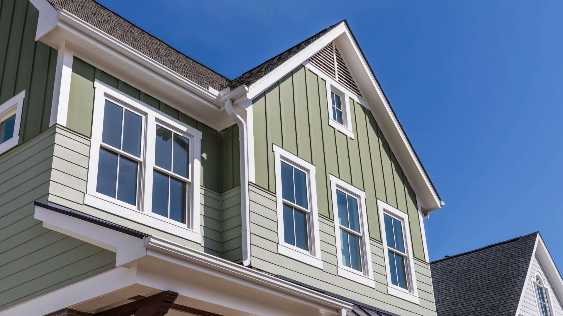 Upward view of a newer home with double-hung windows on its second story