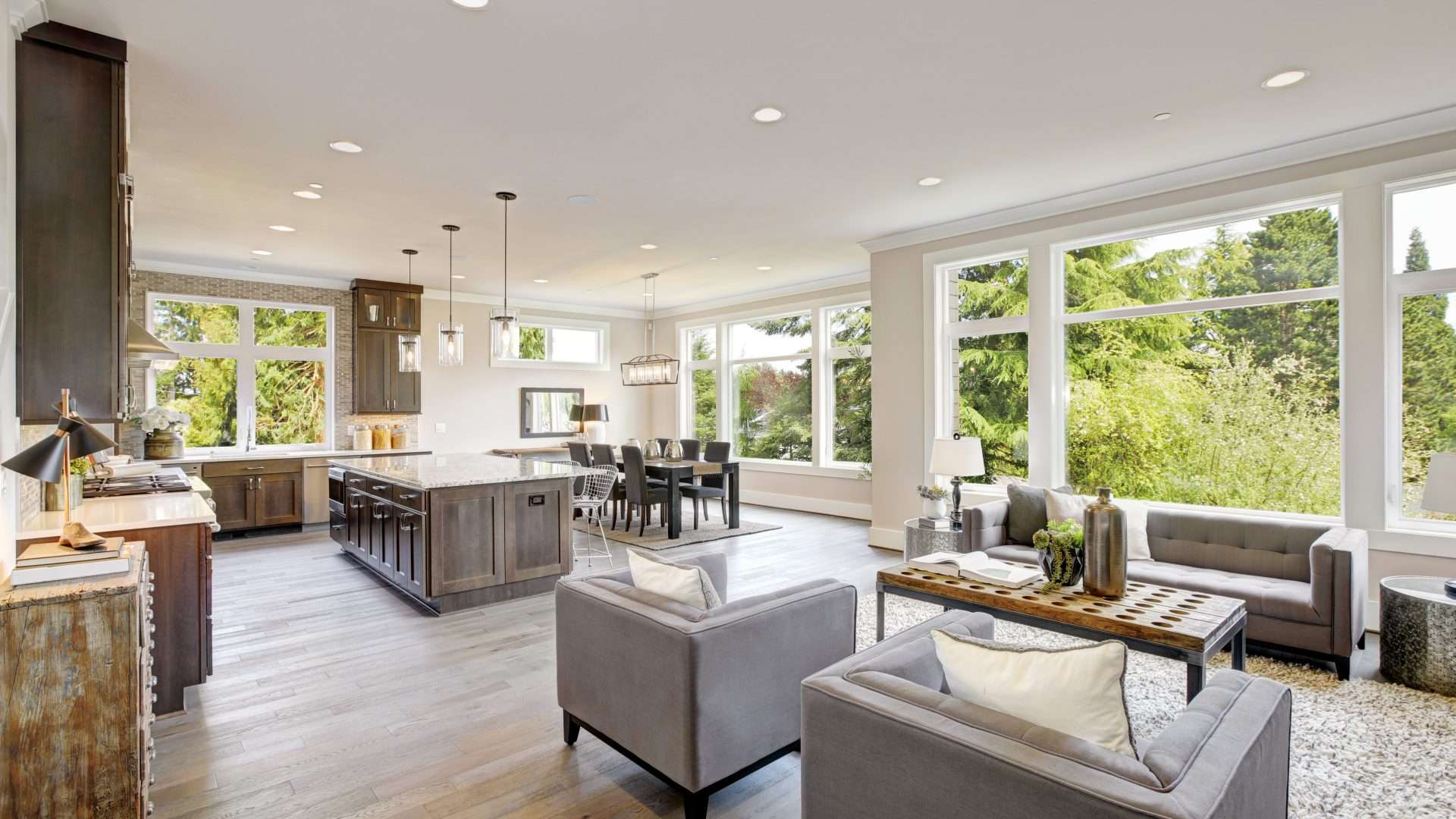 Wide view of a modern kitchen/dining/living room with multiple types of windows, including casement windows