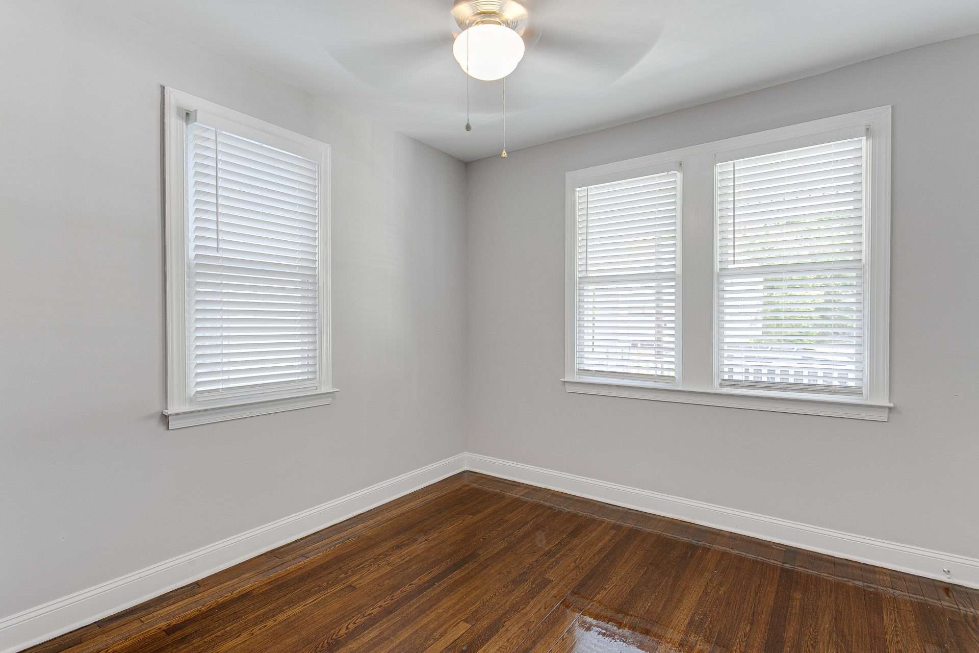 Double-hung windows with blinds from inside an empty bedroom