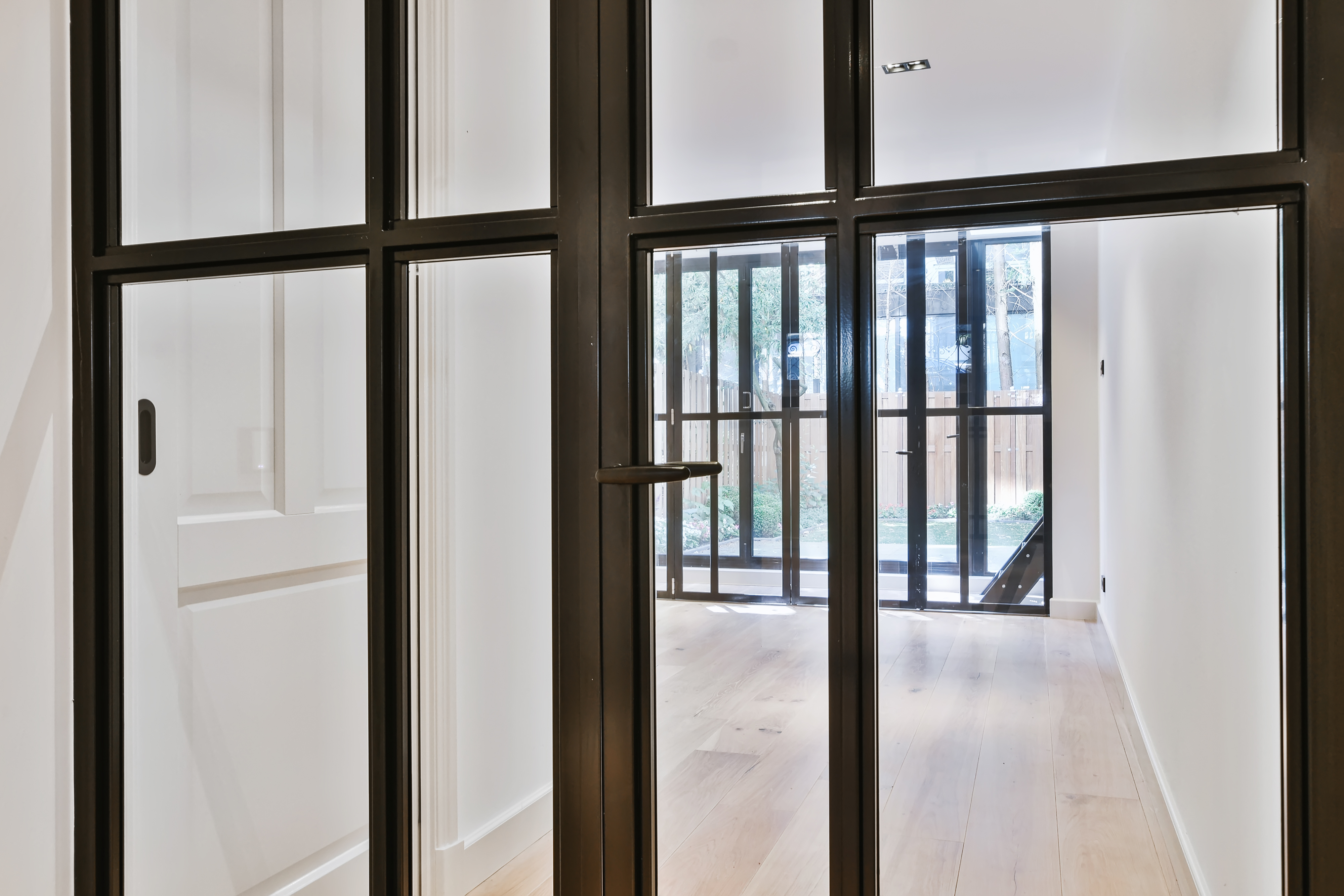 Amazing Doors in Rye, NY | Rockman Windows & Doors A view through a glass door with black metal frames.