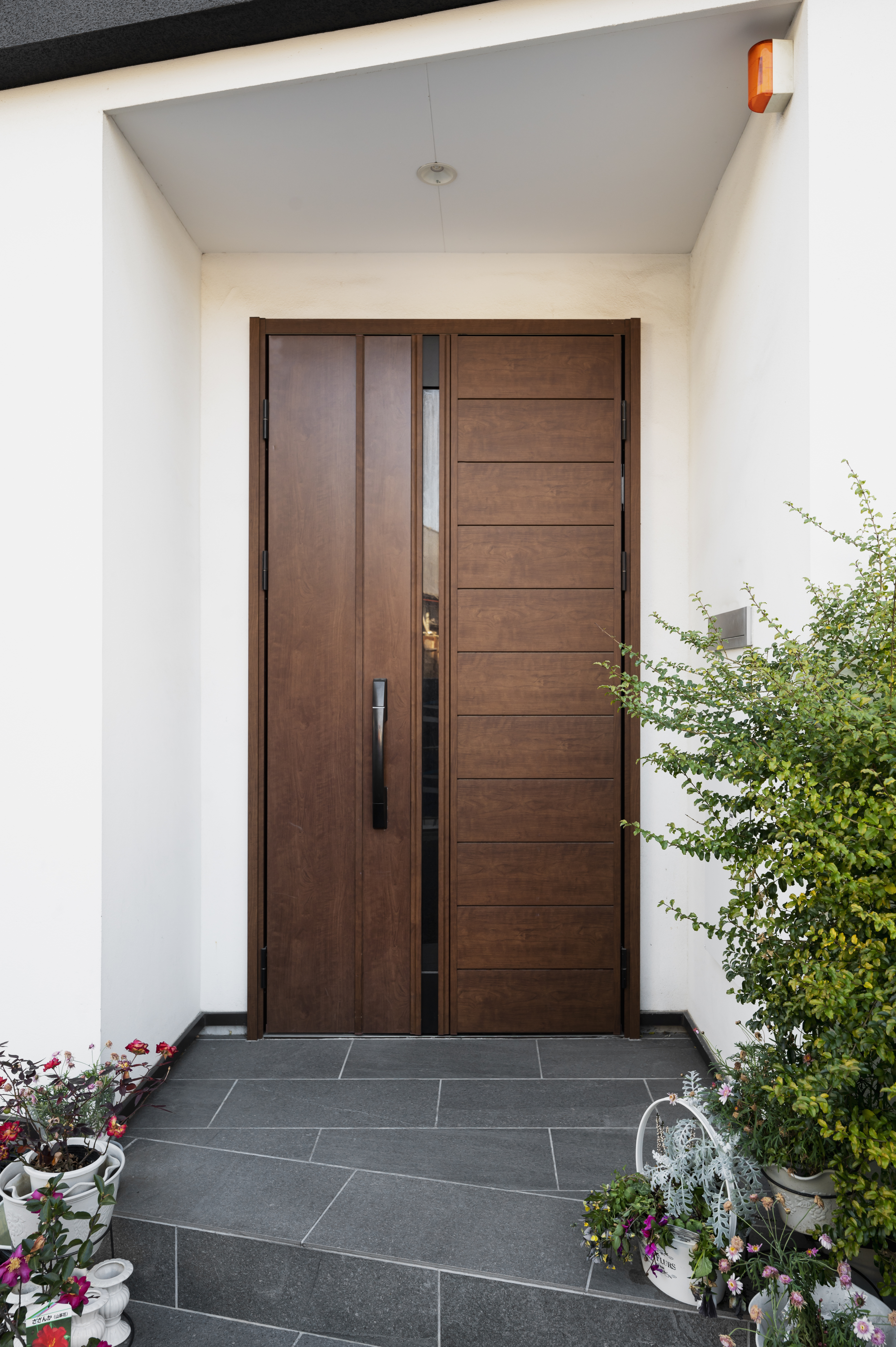 Modern Luxury Doors Supplied In Rye, NY | Rockman Windows & Doors A sleek wooden pivot door with metal hardware installed on a luxury home in Rye, NY.