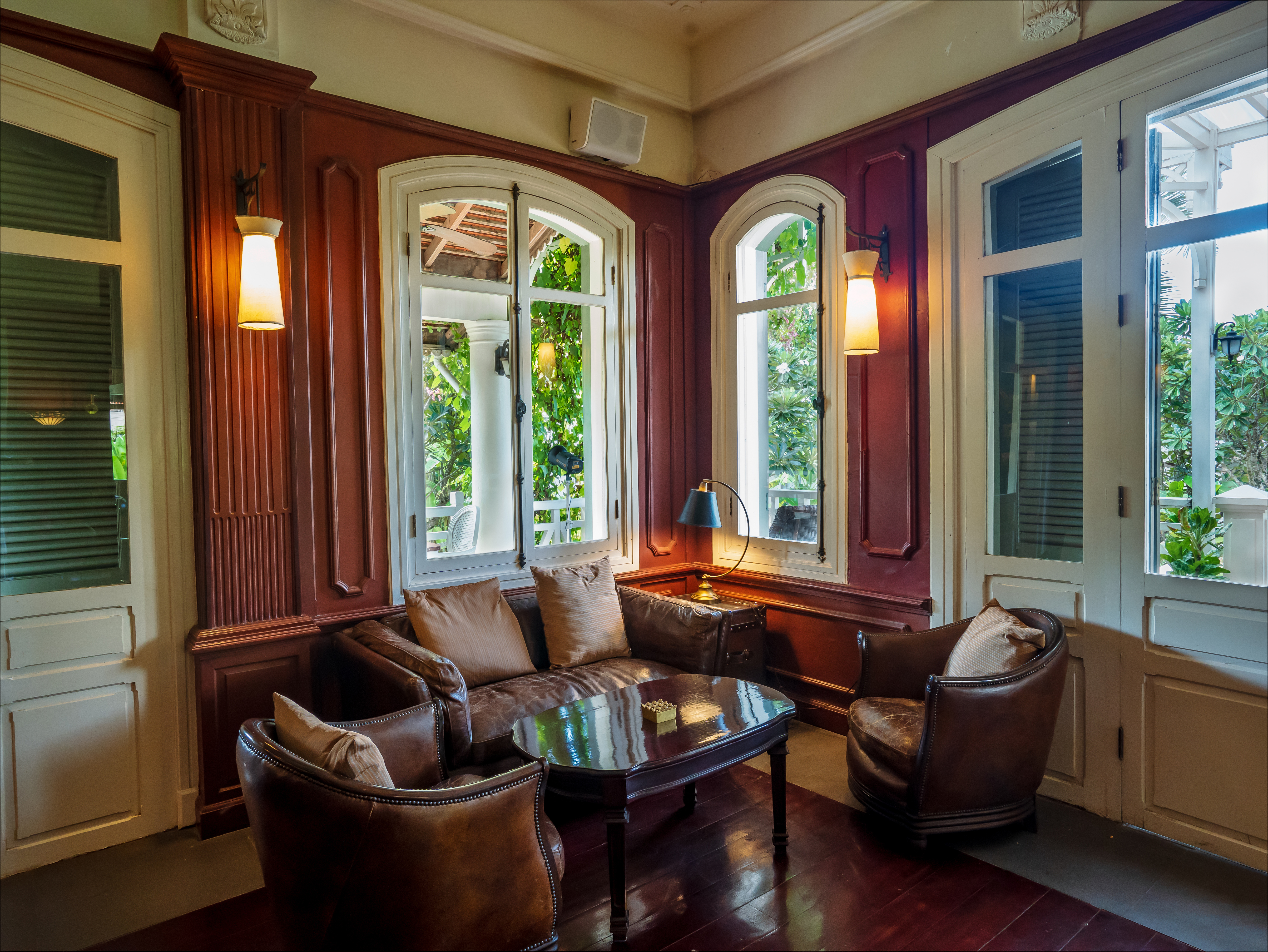 Secure Windows In Greenwich, CT | Rockman Windows And Doors A quaint room with leather furniture, a small table, and arched windows.