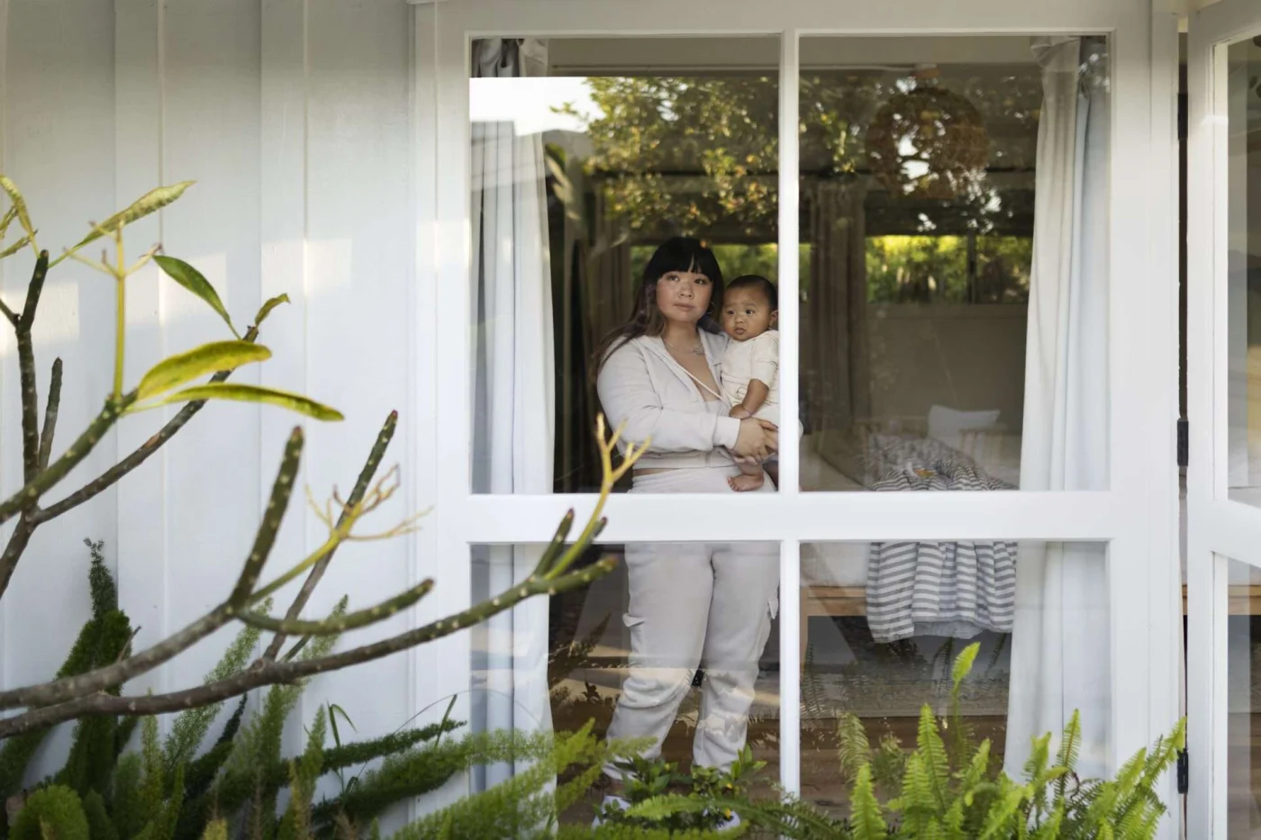 Best Double Hung Windows In Cold Spring, NY A person and child looking out a beautiful window seen from the outside.